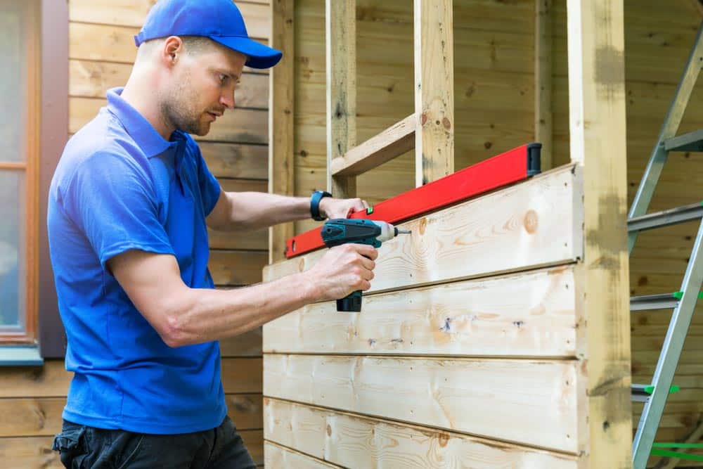 Man Extending A Shed